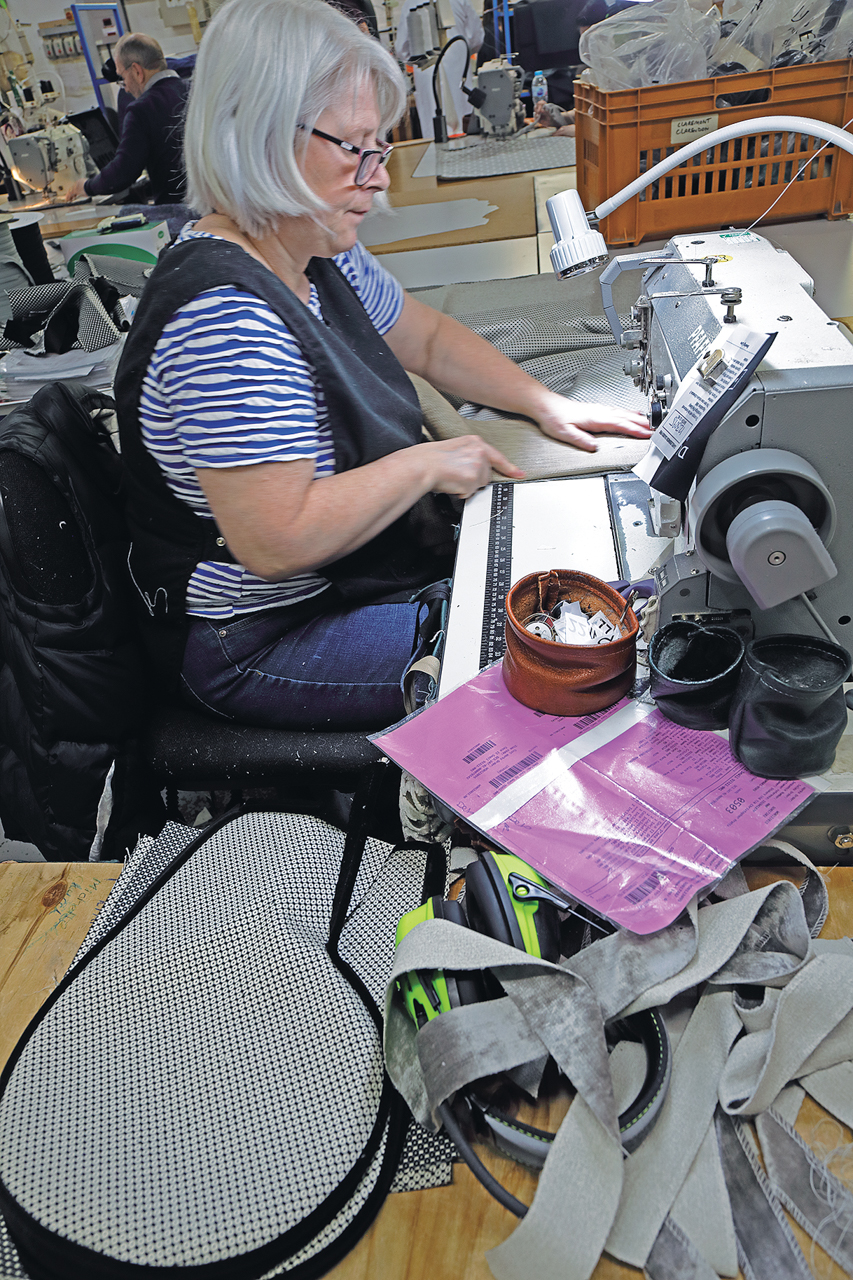 ひじ掛け部の縫製をする女性