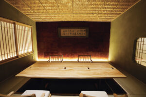 「神楽坂 さんが」の２階の個室の一つ「玄庵」には、柿渋の和紙を貼った壁に北大路魯山人による書が。