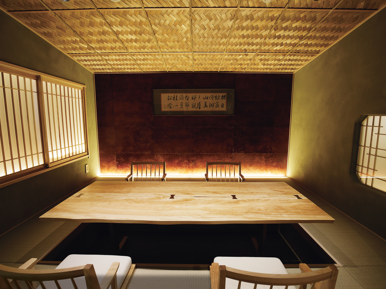 「神楽坂 さんが」の２階の個室の一つ「玄庵」には、柿渋の和紙を貼った壁に北大路魯山人による書が。