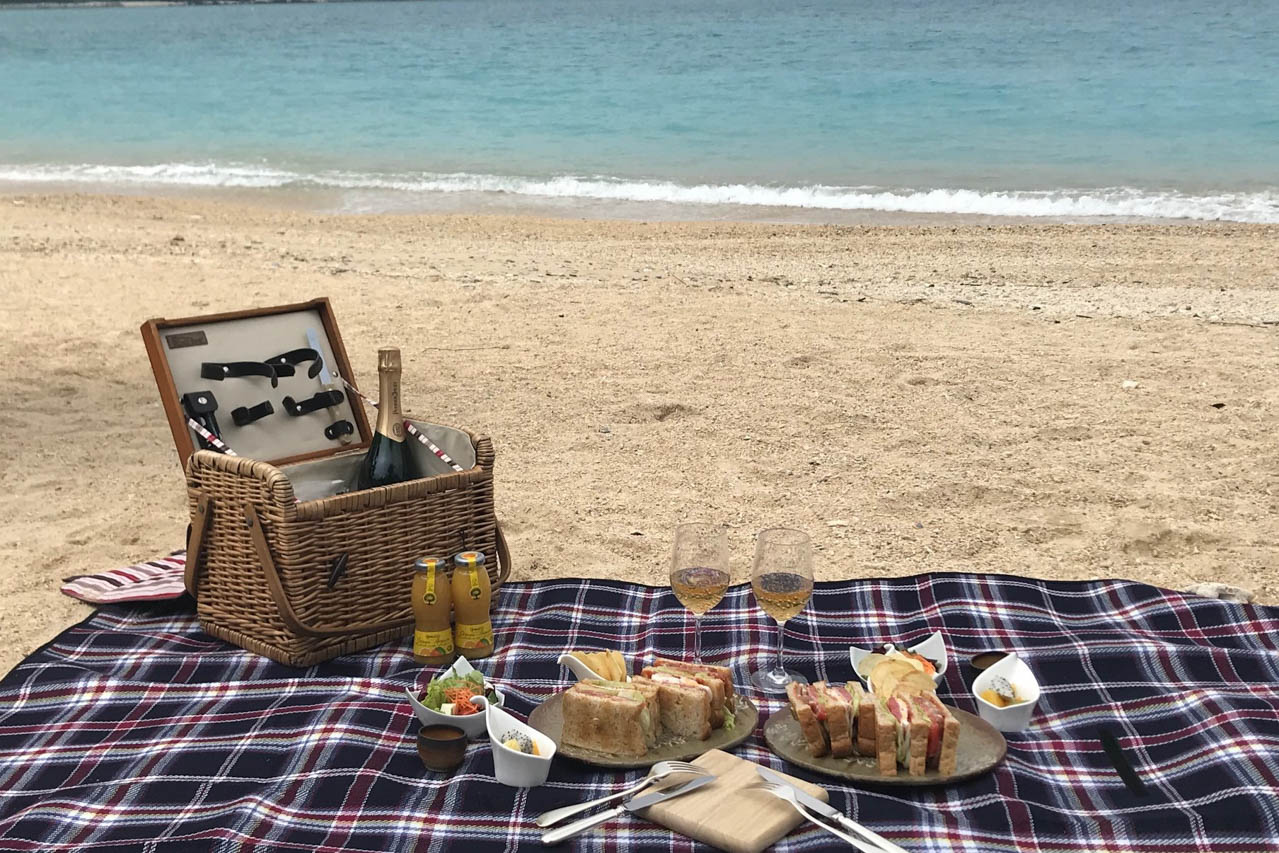 名護湾の白浜にピクニックボックスを堪能する優雅な時間。