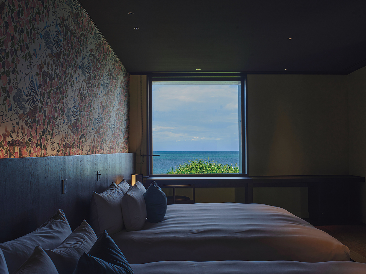 星のや沖縄。ベッドルームの窓の外に穏やかな海